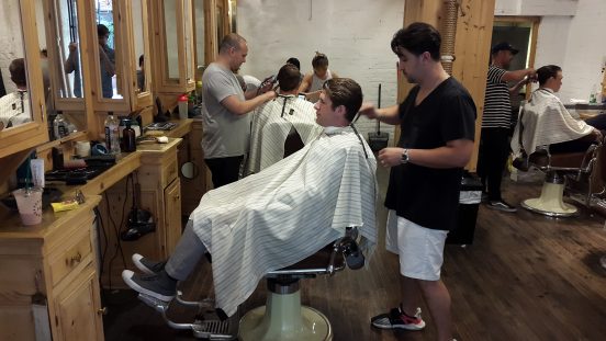 Richard Ocejo krijgt een knipbeurt bij ambachtelijke kapper Freemans Sporting Club Barber. Foto: Hans Klis